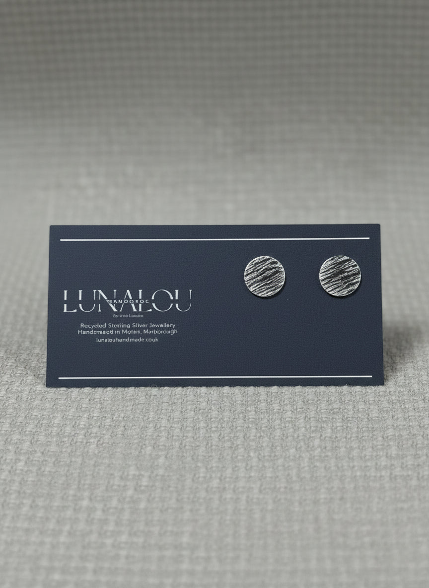 Round stud earrings with a stripy and rippled hammered texture. Made from recycled sterling silver.