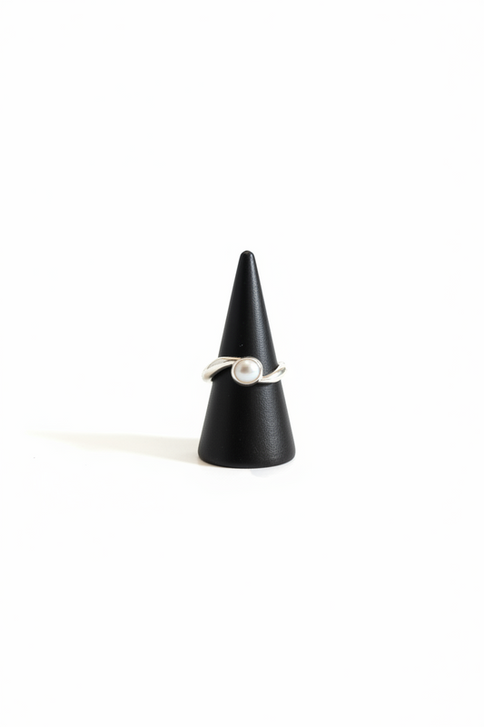 Handmade freshwater pearl ring with flowing recycled sterling silver band on black ring stand.