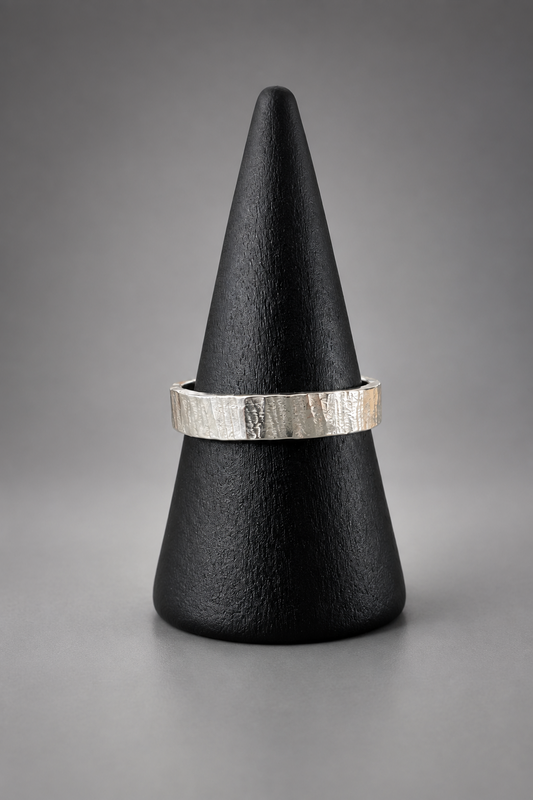     Handmade textured silver Ripple Ring displayed on a black ring stand